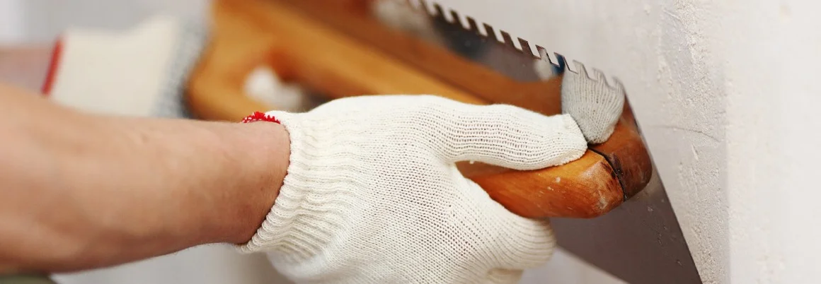 Person verputzt Wand mit Kelle